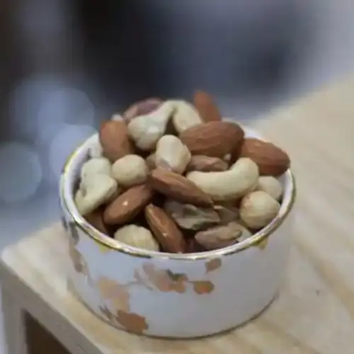 ظرف آجیل تازه و سالم با ترکیبی از بادام، پسته، گردو و فندق، منبع غنی پروتئین و چربی‌های سالم، مناسب برای تقویت انرژی و سلامت بدن.