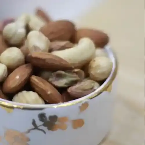 ظرف آجیل تازه و سالم با ترکیبی از بادام، پسته، گردو و فندق، منبع غنی پروتئین و چربی‌های سالم، مناسب برای تقویت انرژی و سلامت بدن.